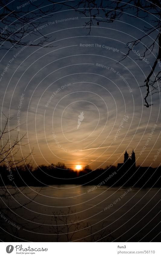 Sunset in Magdeburg Lake Winter Clouds Portrait format Dome orange Blue Ice Sky