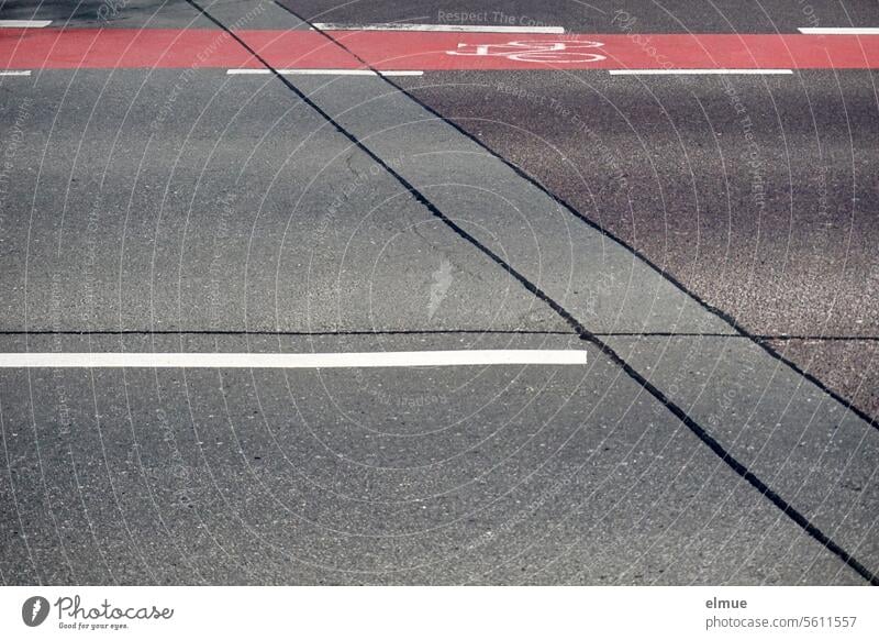 Cycle path marked in red with a bicycle pictogram on the edge of an asphalt road cycle path Pictogram Asphalt lines Road marking Lane markings Cycling