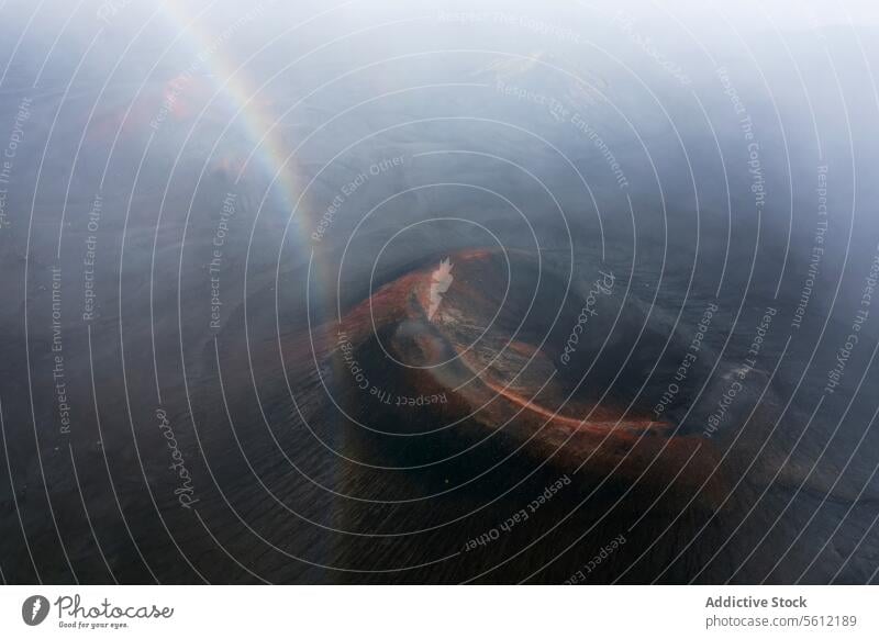 Mystical Rainbow Over Iceland's River Basin iceland aerial view river basin rainbow mist landscape rugged arch nature outdoors misty ethereal mystical faint