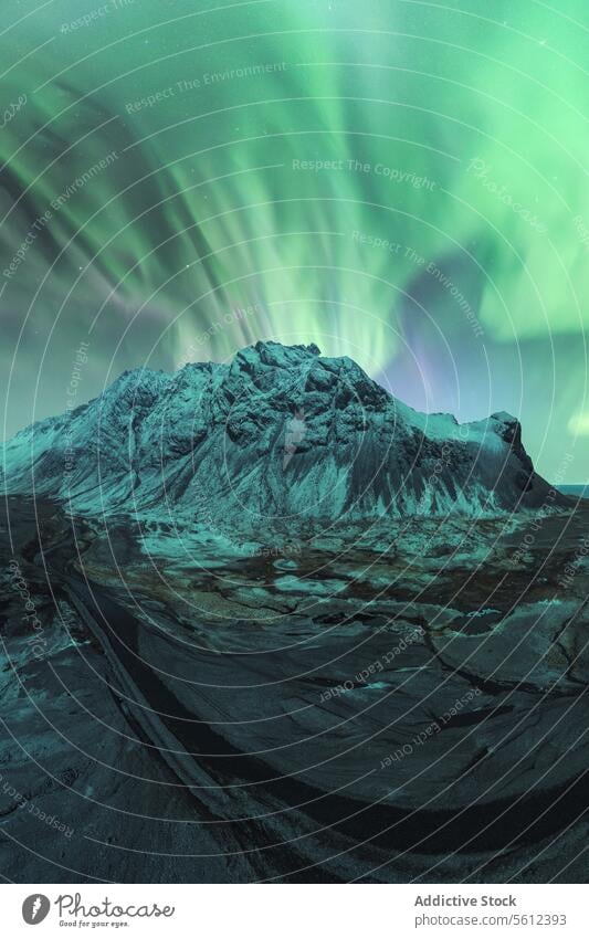 Northern Lights dance over an Icelandic mountain landscape aurora borealis northern lights iceland natural light show wilderness rugged spectacle display sky