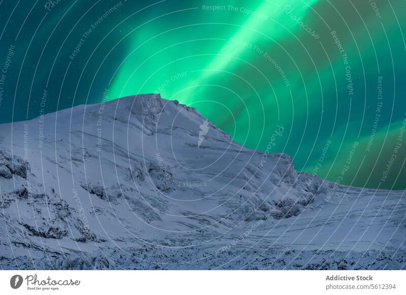 Northern Lights Dance Over Snowy Icelandic Mountain aurora borealis northern lights iceland mountain snow night sky illumination landscape nature winter cold