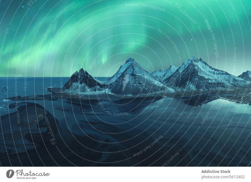 Mystical Northern Lights Over Snowy Icelandic Peaks iceland northern lights aurora borealis mountain snow peak night sky natural wonder landscape arctic cold