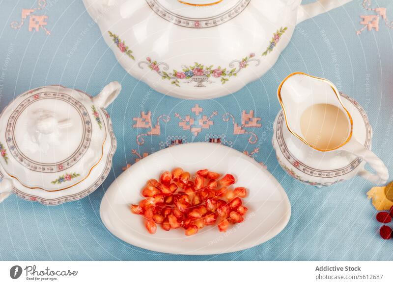 Elegant porcelain tea set with goji berries on a saucer berry plate vintage cup teapot pastel blue background tableware elegance traditional drink afternoon