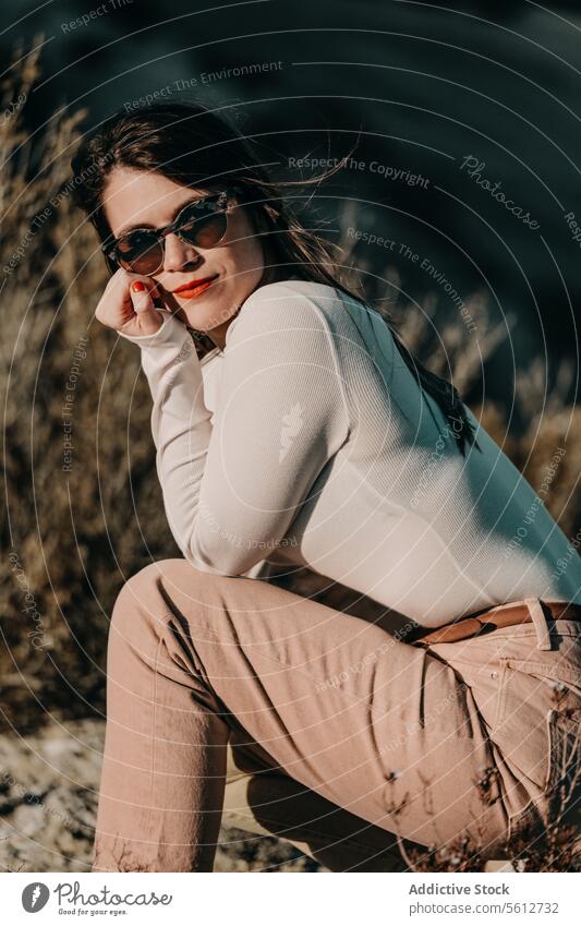 Woman in sunglasses sits thoughtfully amidst the Monegros Desert woman desert portrait style fashion solitude Spain looking at camera sitting nature outdoor