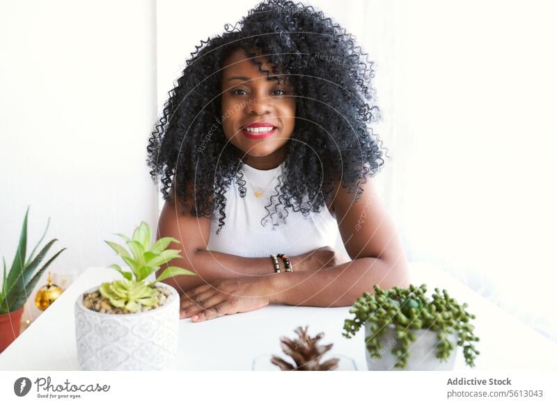 Black curly female with arms crossed woman afro confident beautiful white home black apartment lifestyle domestic lady casual attire calm dark hair free time