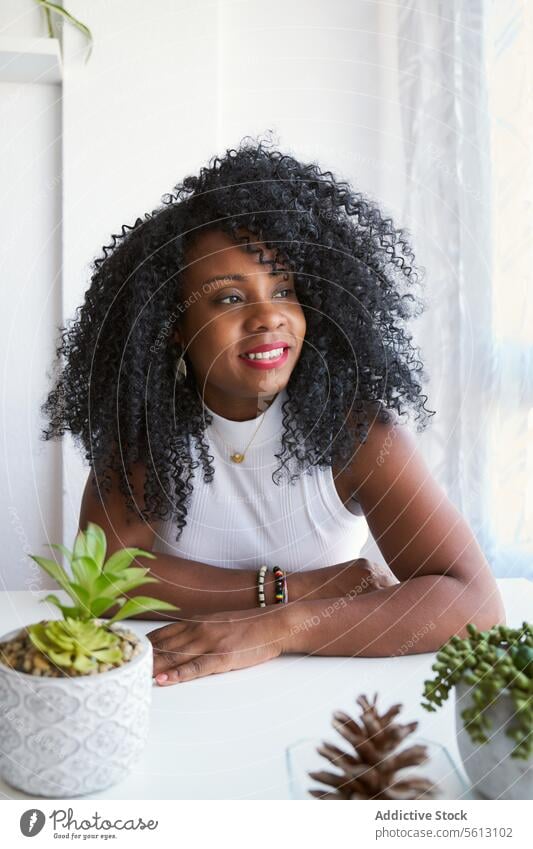 Black curly female with arms crossed woman afro confident beautiful white home black apartment lifestyle domestic lady casual attire calm dark hair free time