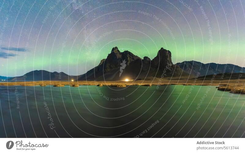 Majestic aurora borealis display over mountainous landscape in Eystrahorn, Iceland northern lights night sky star lake reflection natural wonder panorama scenic