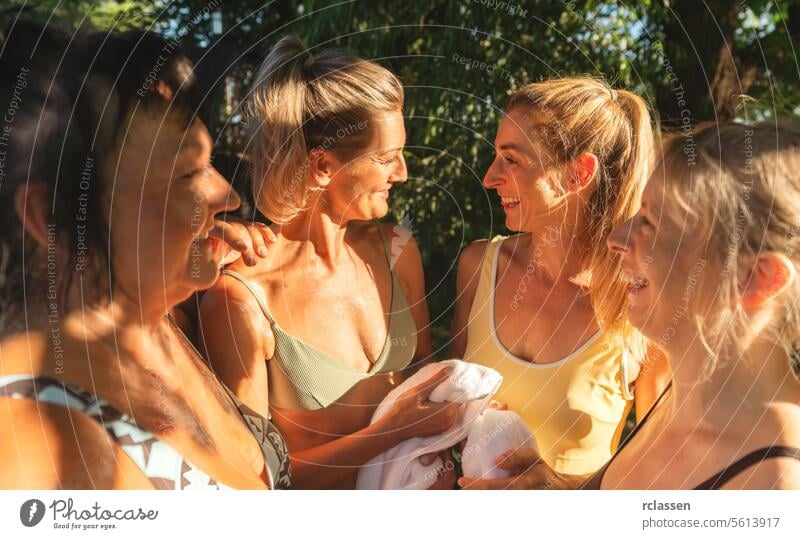 Group of women wrapped in towels after a Finnish sauna, chatting happily finnish sauna relaxation post-sauna happiness wellness bonding friendship leisure