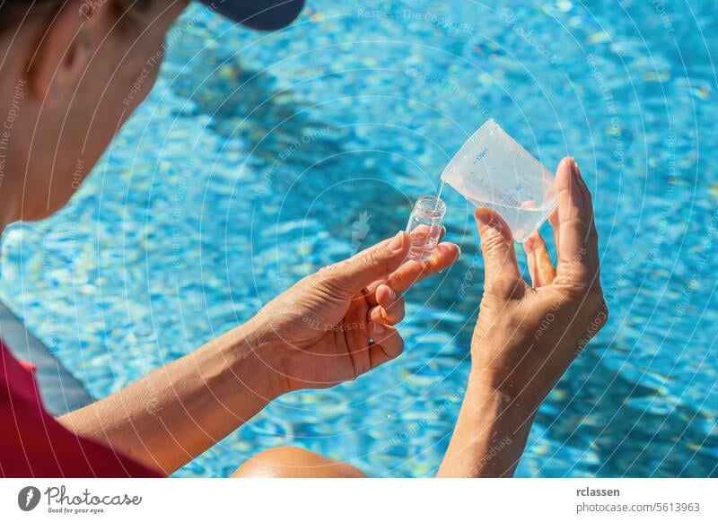 Close-up of hands pouring water into testing vial for PH value test against pool background bottling pool water testing water vial chlorine measure sample