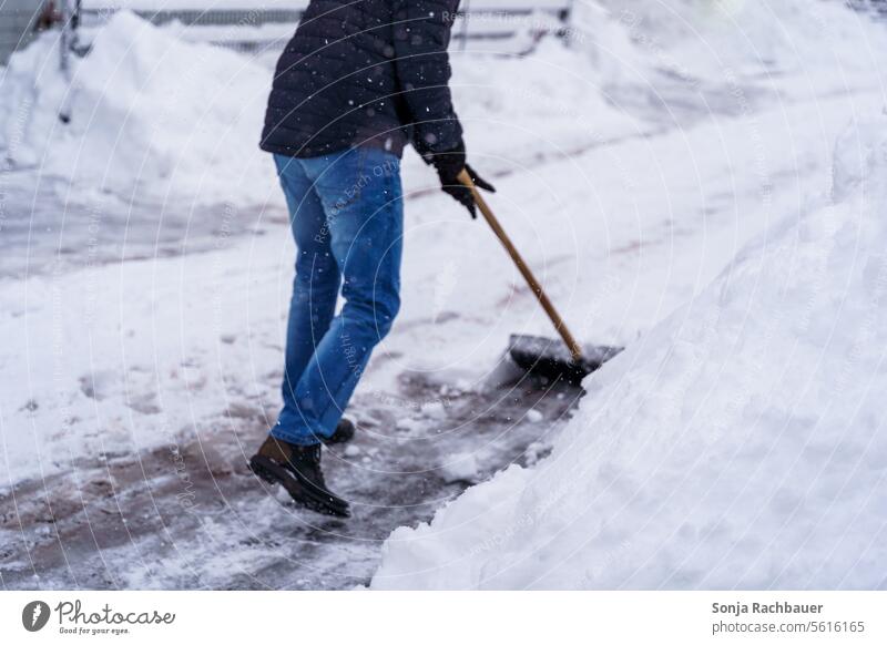 A man clears a road with a snow shovel Snow shovel Man Winter Winter maintenance program Snowfall Street Lanes & trails Snow layer Winter's day Day chill Freeze