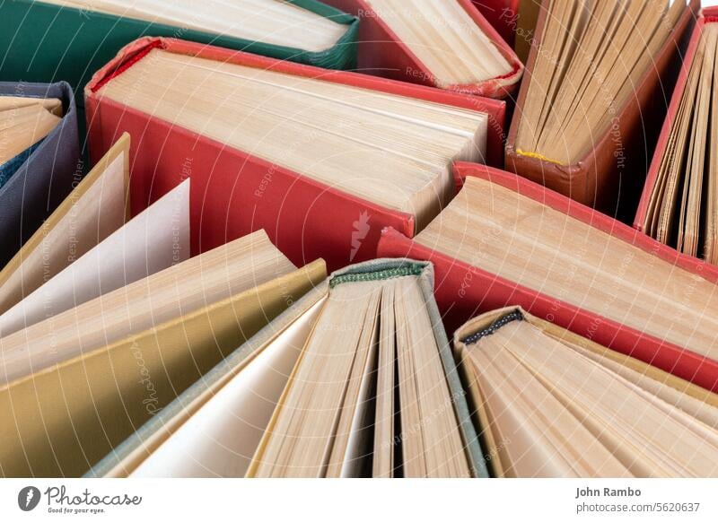 Many different old hardcover physical books close-up background with selective focus and blur education science university wisdom abstract literature library