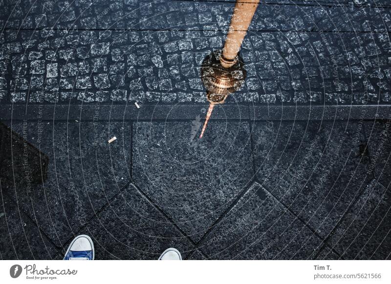 The television tower is reflected in a puddle on the sidewalk Television tower Berlin Reflection Chucks Sidewalk Puddle Colour photo Berlin TV Tower