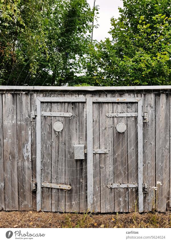 A shack with a face Barn Garage Old boards doors timber construction Metal fitting Hinges Wood Wooden door Entrance Door handle Lock Face