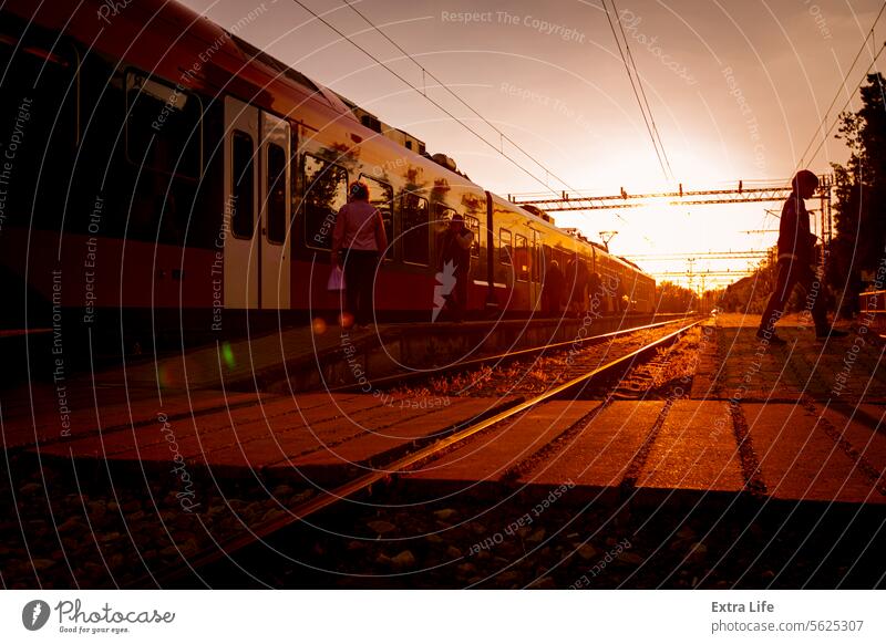 Passenger train is arrived to railway platform station, people walking in hurry, Sun in backlight Arrival Arrive Backlight Backlit Carriages Commute Commuter