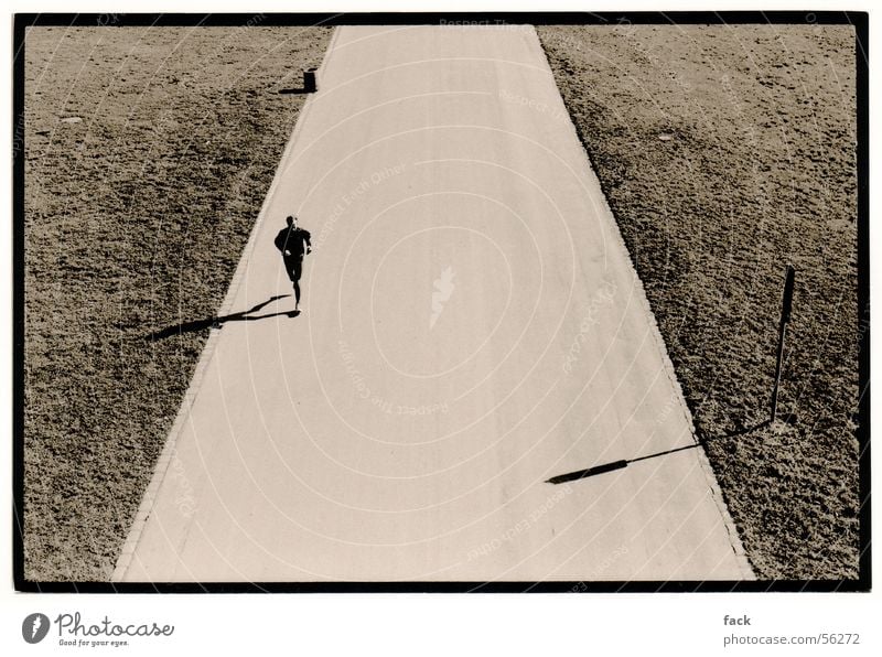 Lonely Jogger Jogging Loneliness Moody Exterior shot Walking Runner Far-off places further away low sun Black & white photo