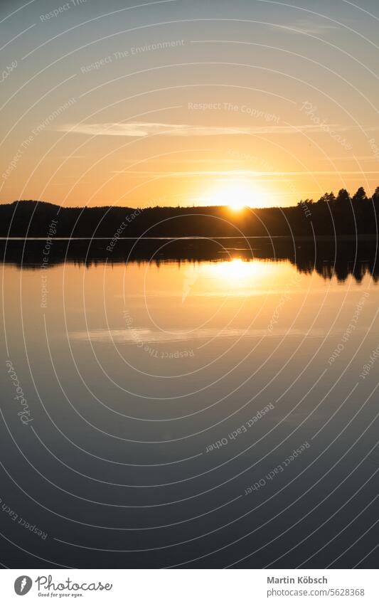 Sunset with reflection on a Swedish lake in Smalland. Romantic evening mood. Lake sunset travel smalland Sweden lightness vacation water see forest recreate