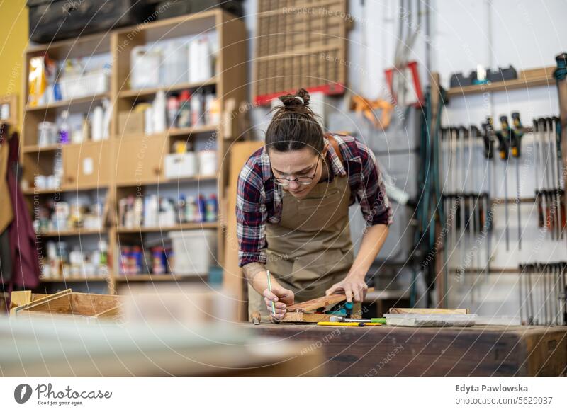 Portrait of young female carpenter working in her workshop Furniture Carpenter Restoring Carpentry wood Chair building Manufacturing Craft Renovation Repairing