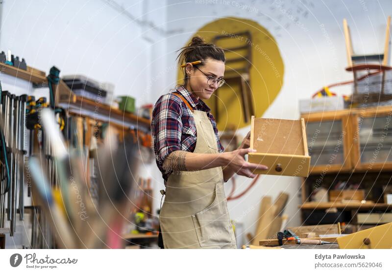 Portrait of young female carpenter working in her workshop Furniture Carpenter Restoring Carpentry wood Chair building Manufacturing Craft Renovation Repairing