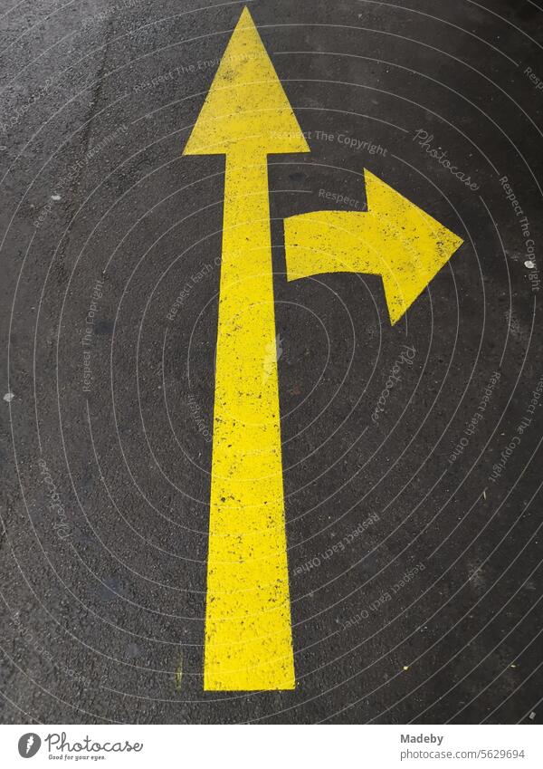 Long yellow arrow and arrow to the right for turners on gray asphalt on the parking deck of a parking garage at Sabiha Gökcen Airport in Istanbul on the Bosphorus in Turkey