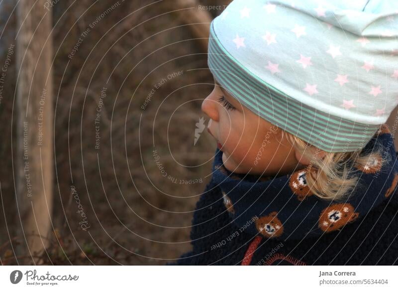 A small child in a hat and scarf spending time outdoors in nature Child Toddler Winter Cold be warmly dressed fresh air salubriously person To go for a walk Cap