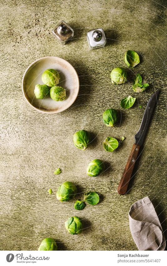 Peeled cabbage sprouts and a knife on a green table. Cabbage sprout Green Raw Vegetable Fresh Knives Cooking Vegetarian diet Preparation Food Table Ingredients