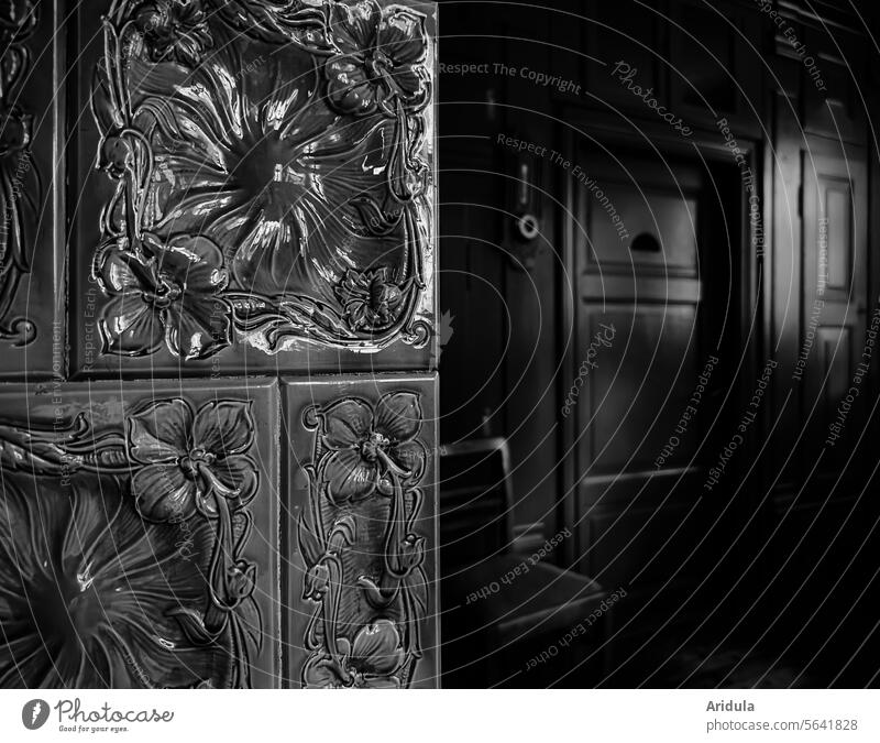 Old floral tiled stove in a dark room b/w kiln Tiled stove decorations splendour Art nouveau Historic Wall (building) Wood door Building Decoration Dark Detail