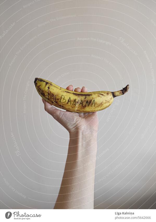 Hand holding a banana Bananas Eating Vitamin Food Organic produce Yellow Delicious Healthy Banana skin Fruit Day Vegetarian diet Deserted Nutrition