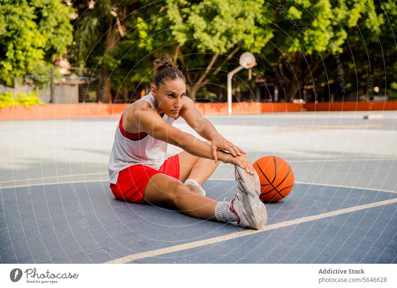 Woman stretching legs before playing basketball on court Sportswoman Basketball Player Warm Up Stretch Exercise Feet Sports Ground Training Determine Playground