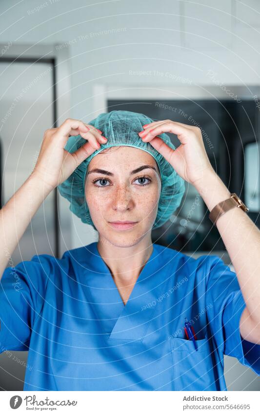 Female surgeon with medical cap and uniform standing in hospital and looking at woman doctor corridor professional clinic medicine specialist work occupation