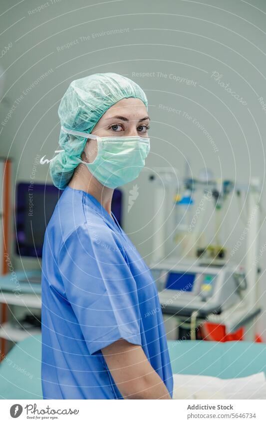 Female surgeon in uniform with medical mask and cap standing at hospital woman doctor clinic work health care medicine surgery equipment operating room protect