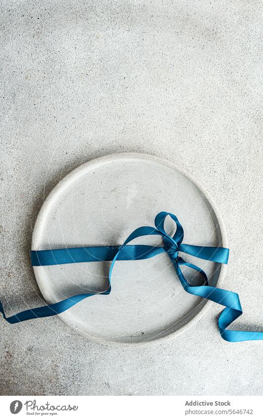 Top view of Minimalist Easter Table Decor minimalist table decor blue ribbon concrete backdrop simplicity texture stylish rough texture celebration chic