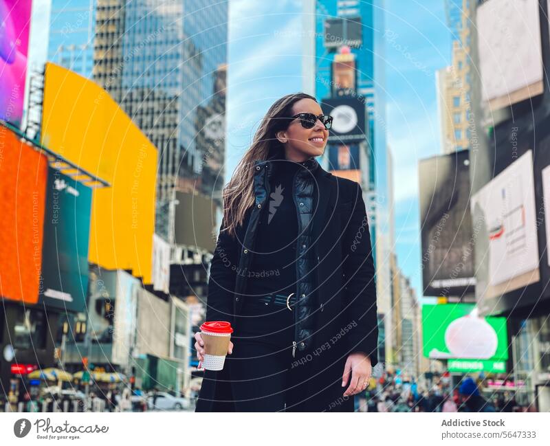 Smiling woman in sunglasses on city street cheerful happy coffee smile toothy smile enjoy female urban positive optimist glad cup young pleasant content