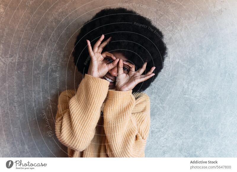 Smiling black woman covering face with hands mask cover face superhero having fun cheerful smile gesture joy sign female african american young afro happy