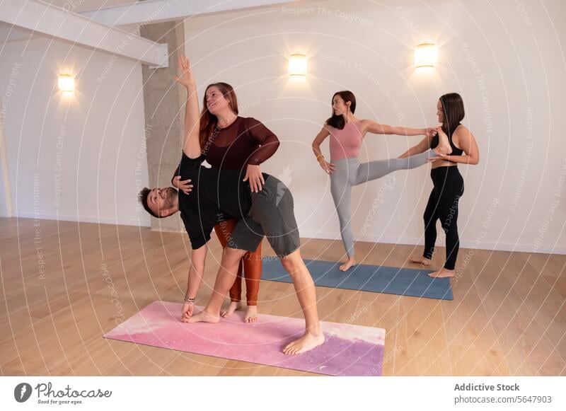 Cheerful woman helping man with stretching exercises guy workout training cheerful assist flexible mat wellbeing smile activity wellness healthy male practice