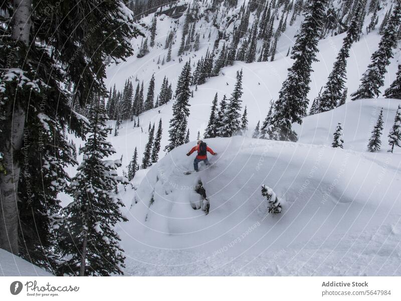 Person snowboarding on snow covered mountain slope person snowboarder snowcapped vacation winter full body anonymous majestic blue sky enjoy canada nature range