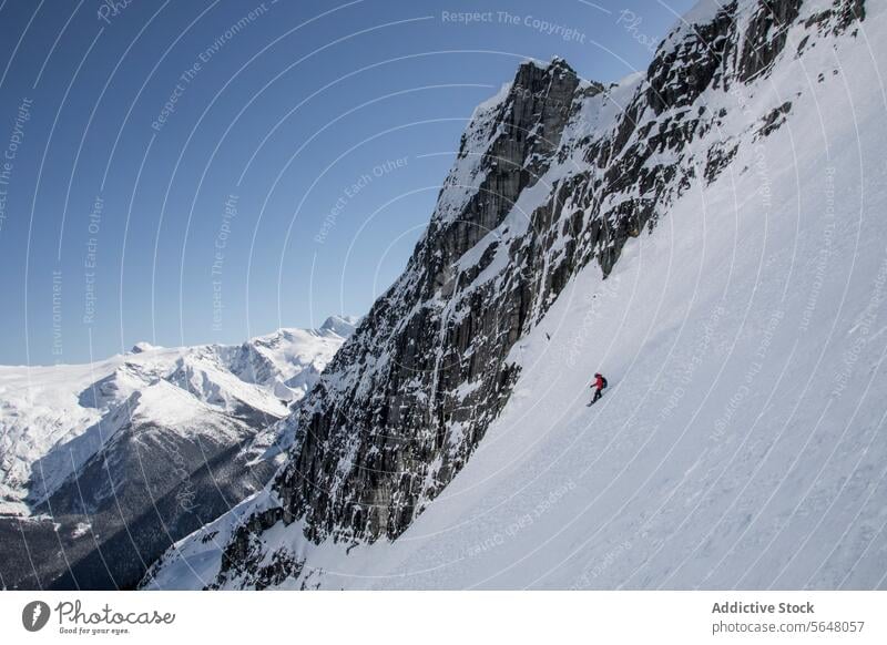 Person snowboarding on snow covered mountain slope person snowboarder snowcapped vacation winter clear sky full body anonymous majestic blue sky enjoy canada