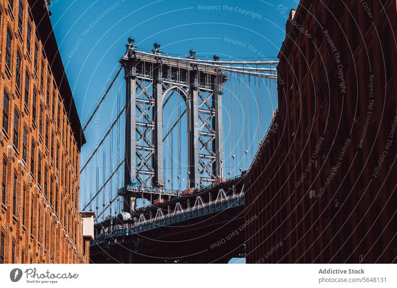 Manhattan Bridge framed between Brooklyn buildings Street DUMBO brick iconic cityscape urban landmark architecture history travel destination New York scene