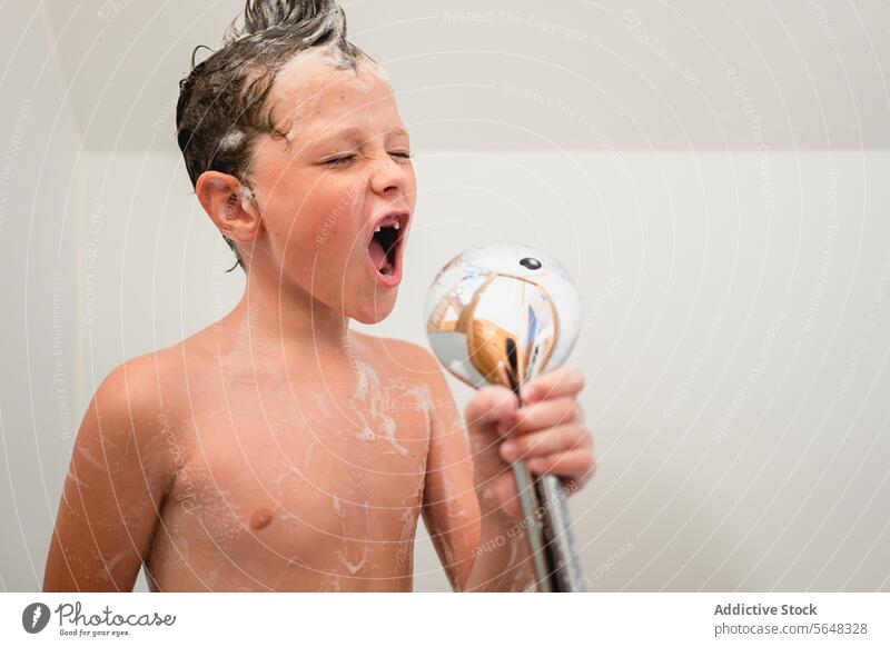 Boy holding hand shower while taking bath in bathroom boy portrait sing pretend dream child shampoo cute foam hygiene childhood having fun wash kid routine care