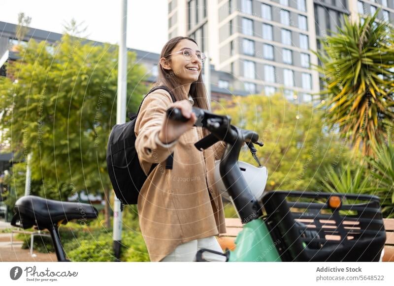 Young woman enjoying a bike ride in the city urban commuter backpack smile eco-friendly lifestyle young female bicycle transport green travel street outdoor