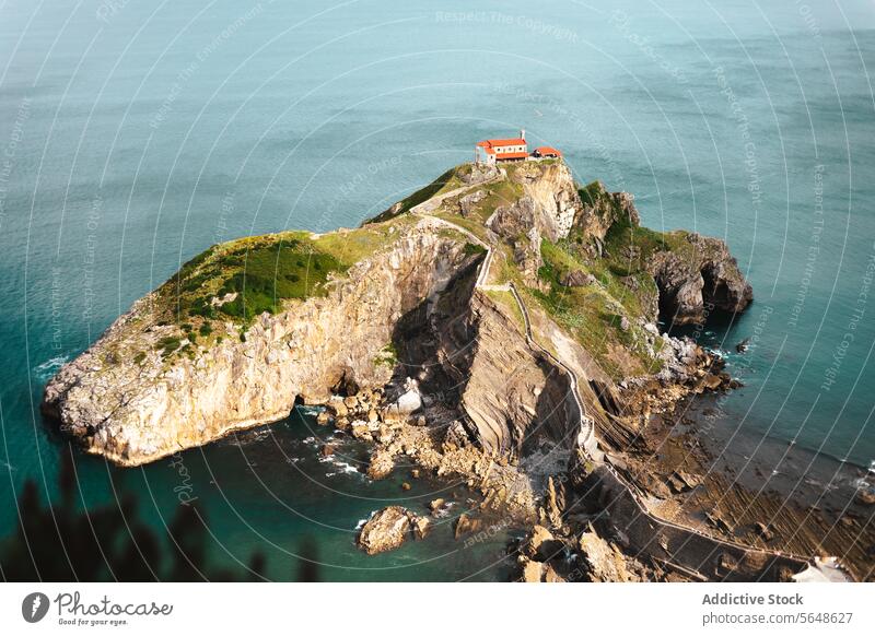 Rocky island in ocean with cliffs nature water landscape rocky turquoise coast sea picturesque seascape shore seashore scenic grass marine idyllic coastline