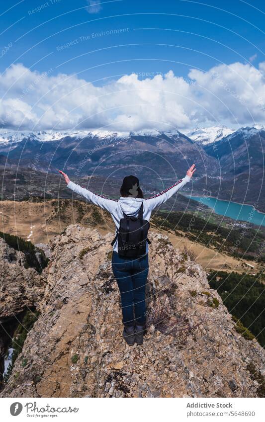 Hiker embracing nature's grandeur in the Pyrenees hiker woman pyrenees mountain peak snow lake turquoise cliff arms raised solitude torla ordesa huesca