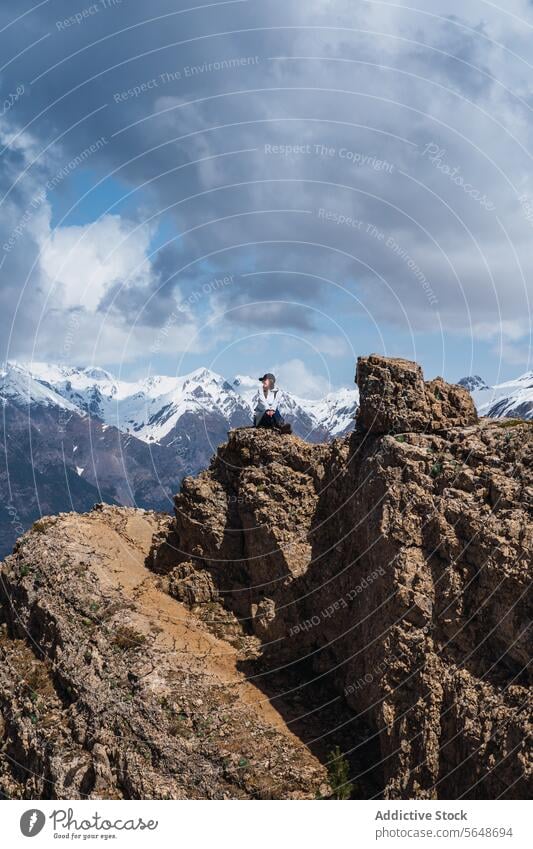 Adventurer woman standing atop a mountain in the Pyrenees adventurer peak pyrenees hiker view snow-capped rocky outcrop ordesa national park torla huesca sky