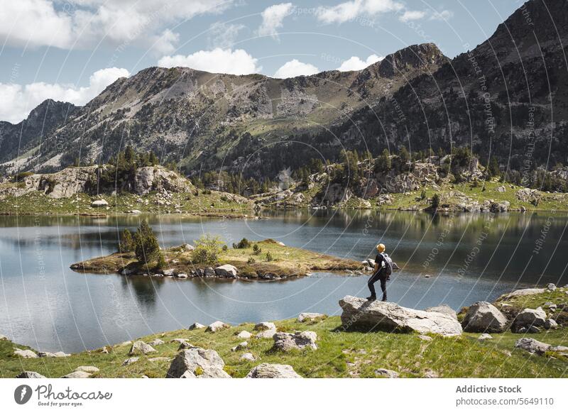 Man standing near calm lake in mountains during vacation Hiker Tourist Lake Mountain National Park Adventure Landscape Reflection Traveler Journey Tourism