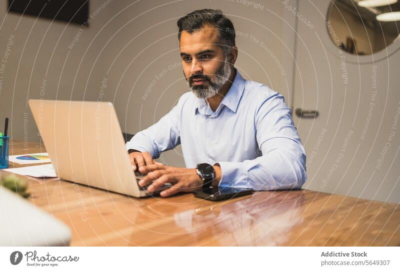 Focused businessman using laptop for working on new project in modern office manager focus serious pc netbook workplace browsing table internet busy surfing