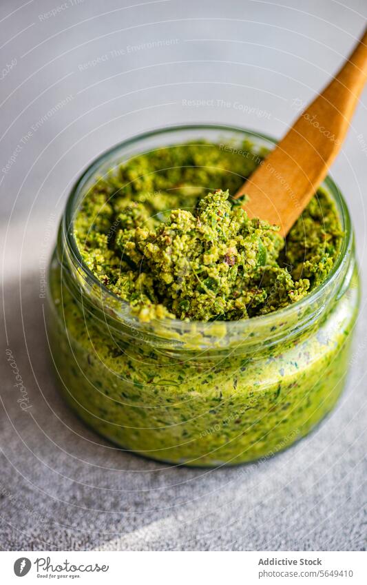 Glass jar of cashew mint pesto sauce on table prepare green healthy meal home fresh from above food healthy food vegan organic raw spoon kitchen recipe diet