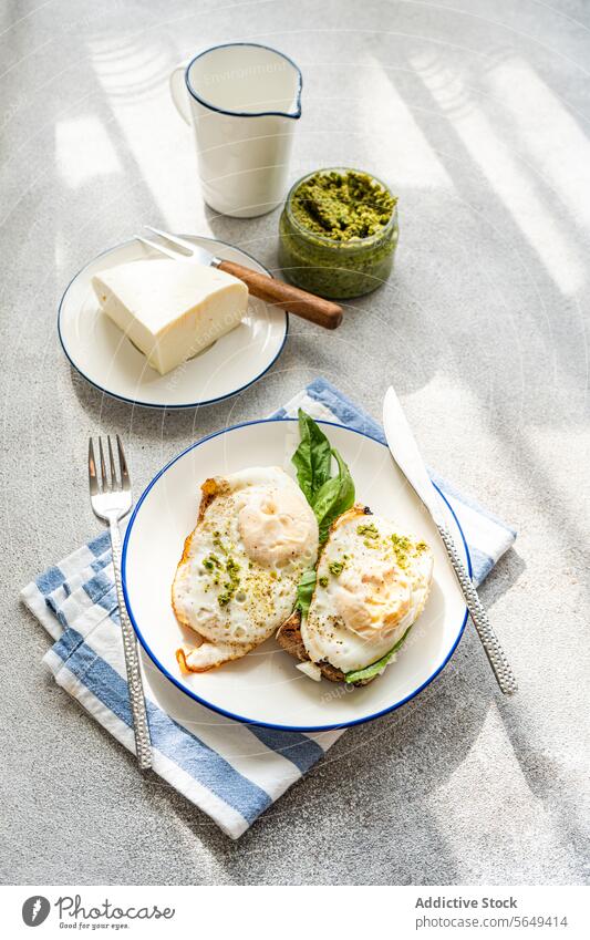 Plate of healthy meal of toast with fried eggs spinach leaves and sauce pesto breakfast herb serve cheese yummy green fresh table food dish high angle plate