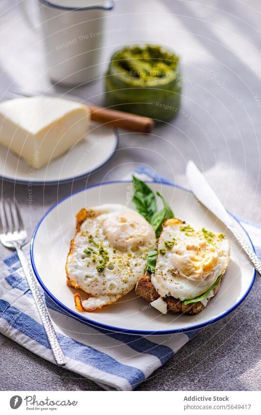 Plate of healthy meal of toast with fried eggs spinach leaves and sauce pesto breakfast herb serve cheese yummy green fresh table food dish high angle plate