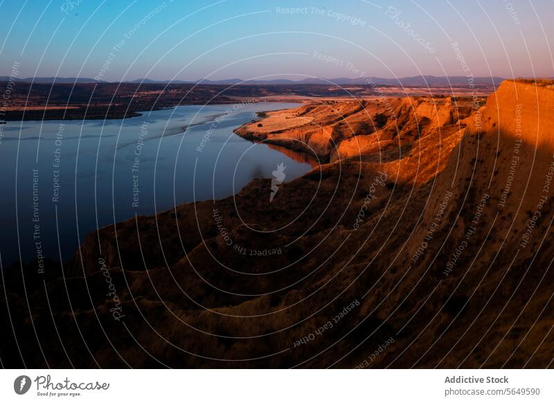 A serene twilight descends over the rugged terrain of Burujón Toledo, casting a soft glow on the meandering river landscape dusk sunset natural beauty panoramic