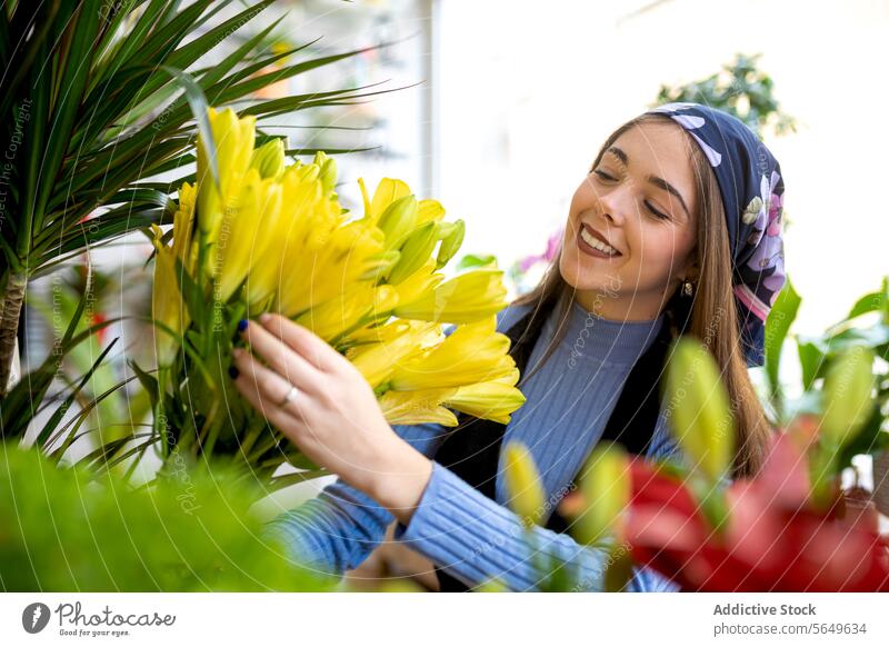 Happy woman arranging yellow flowers in floristry owner arrange smile work bouquet blossom bloom floral female fresh job young cheerful casual shop lady plant