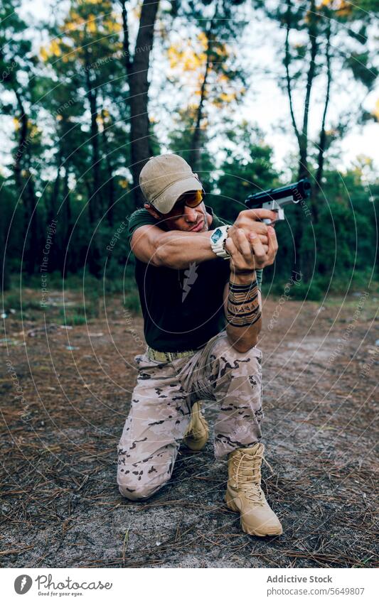 Full body of Military soldier in uniform and cap aiming with gun against forest man commando handgun weapon army special force military blur mission firearm